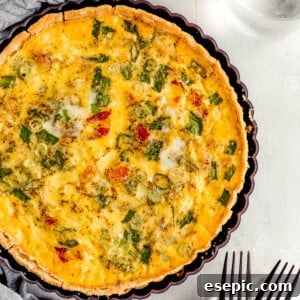 A Bacon Quiche Lorraine Beside a Gray Tablecloth and a Glass of Water