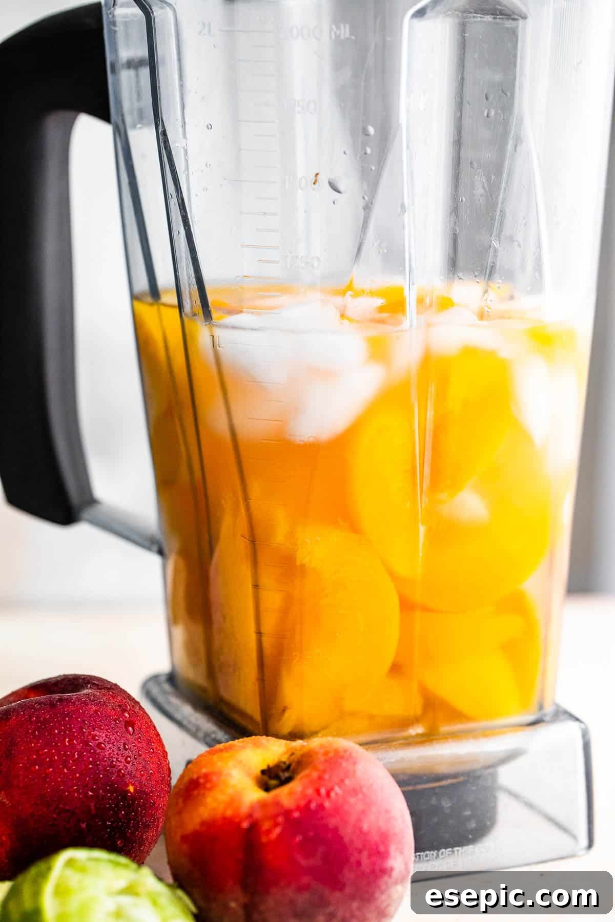 Sweet and refreshing Peach Daiquiri made with fresh peaches, lime juice, and white rum – a perfect summer cocktail! fresh peaches, rum, and ice in a blender, ready to be transformed into a peach daiquiri