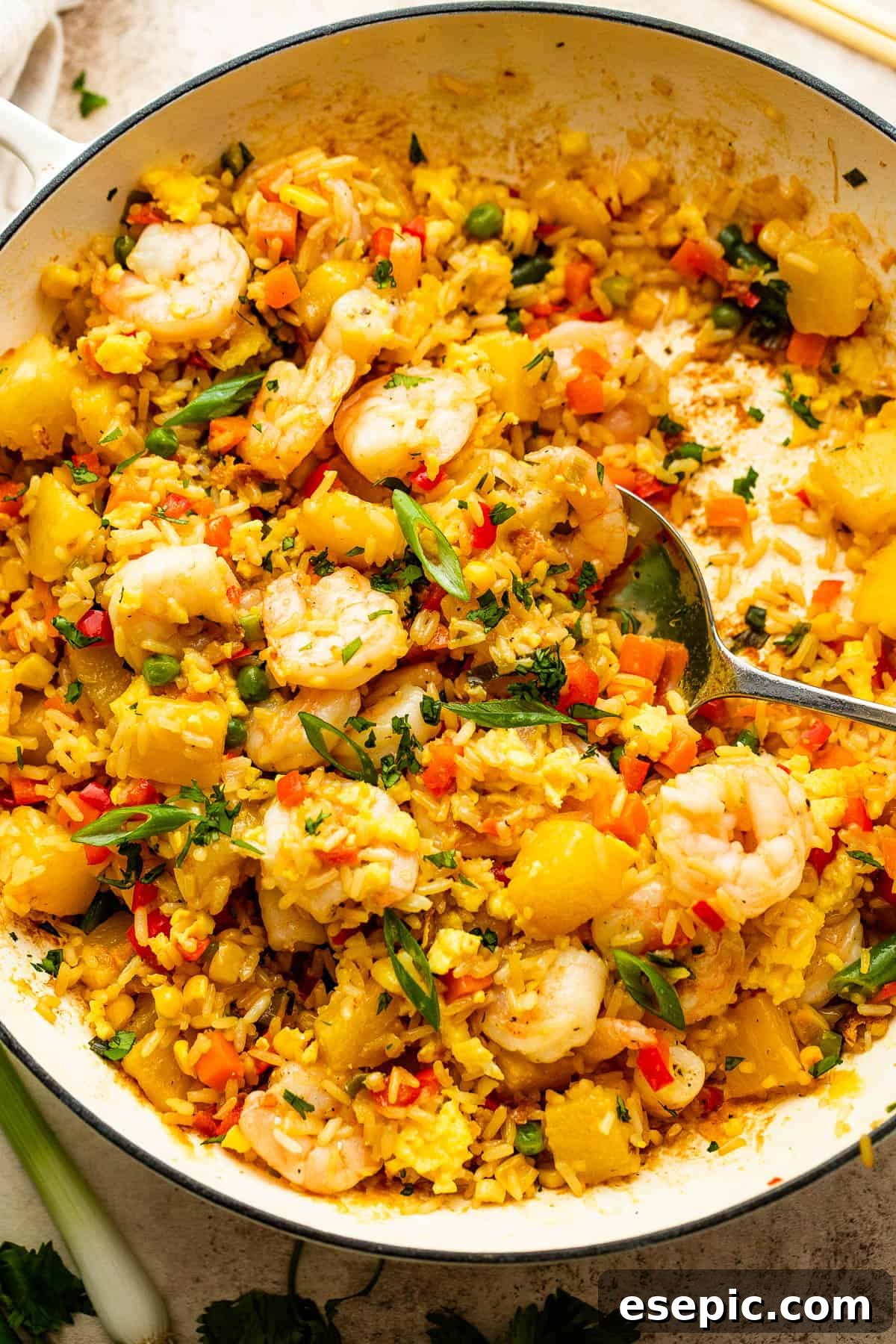 Tropical Pineapple Shrimp Fried Rice 6 White cast iron skillet with Shrimp Fried Rice and pineapple chunks, presented attractively.