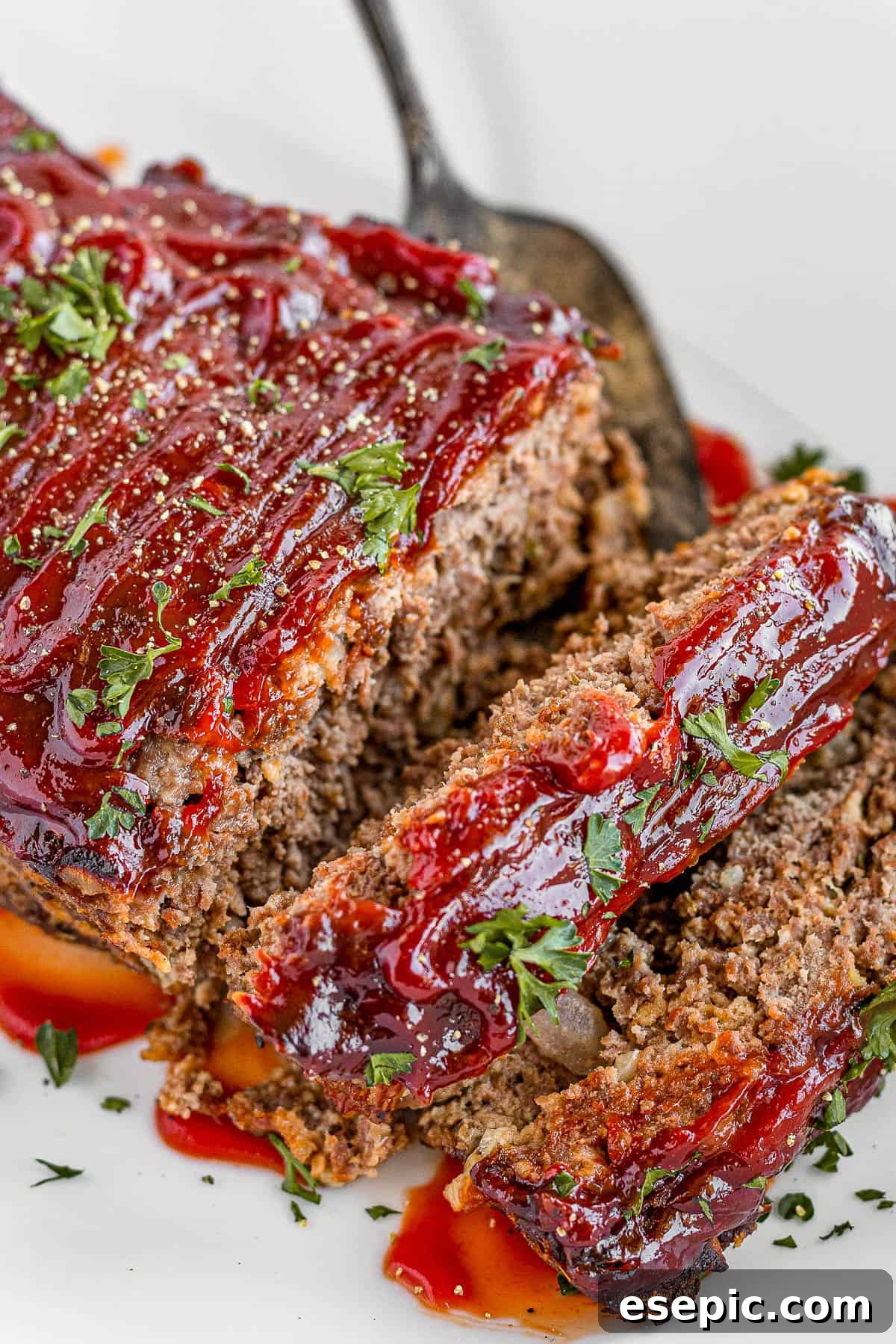 A family-friendly classic, this easy meatloaf recipe gets extra flavor from barbecue sauce, plenty of garlic, and Italian seasoning. Meatloaf Covered in Barbecue Sauce on a White Serving Platter