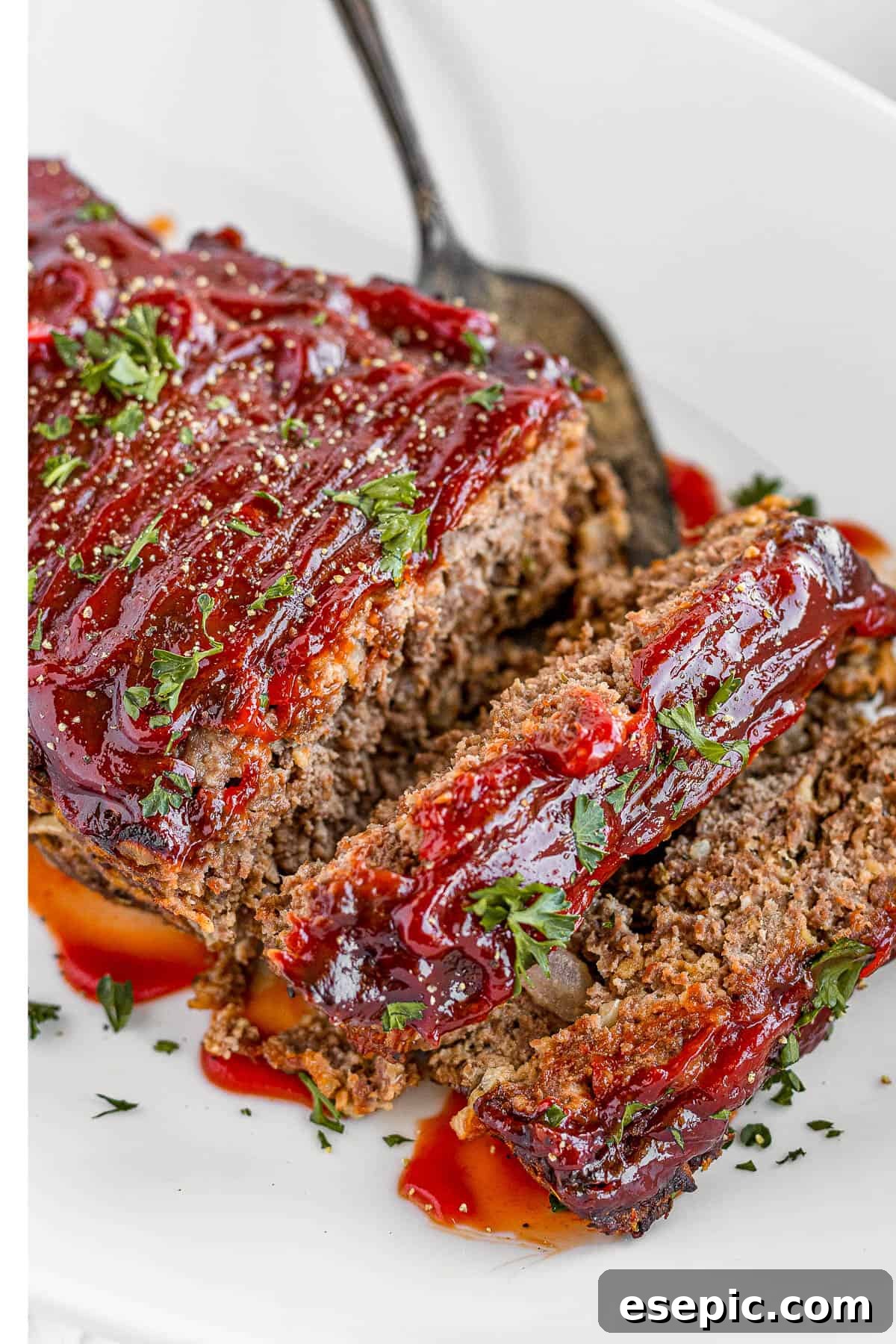 A family-friendly classic, this easy meatloaf recipe gets extra flavor from barbecue sauce, plenty of garlic, and Italian seasoning. Meatloaf Covered in Barbecue Sauce on a White Serving Platter