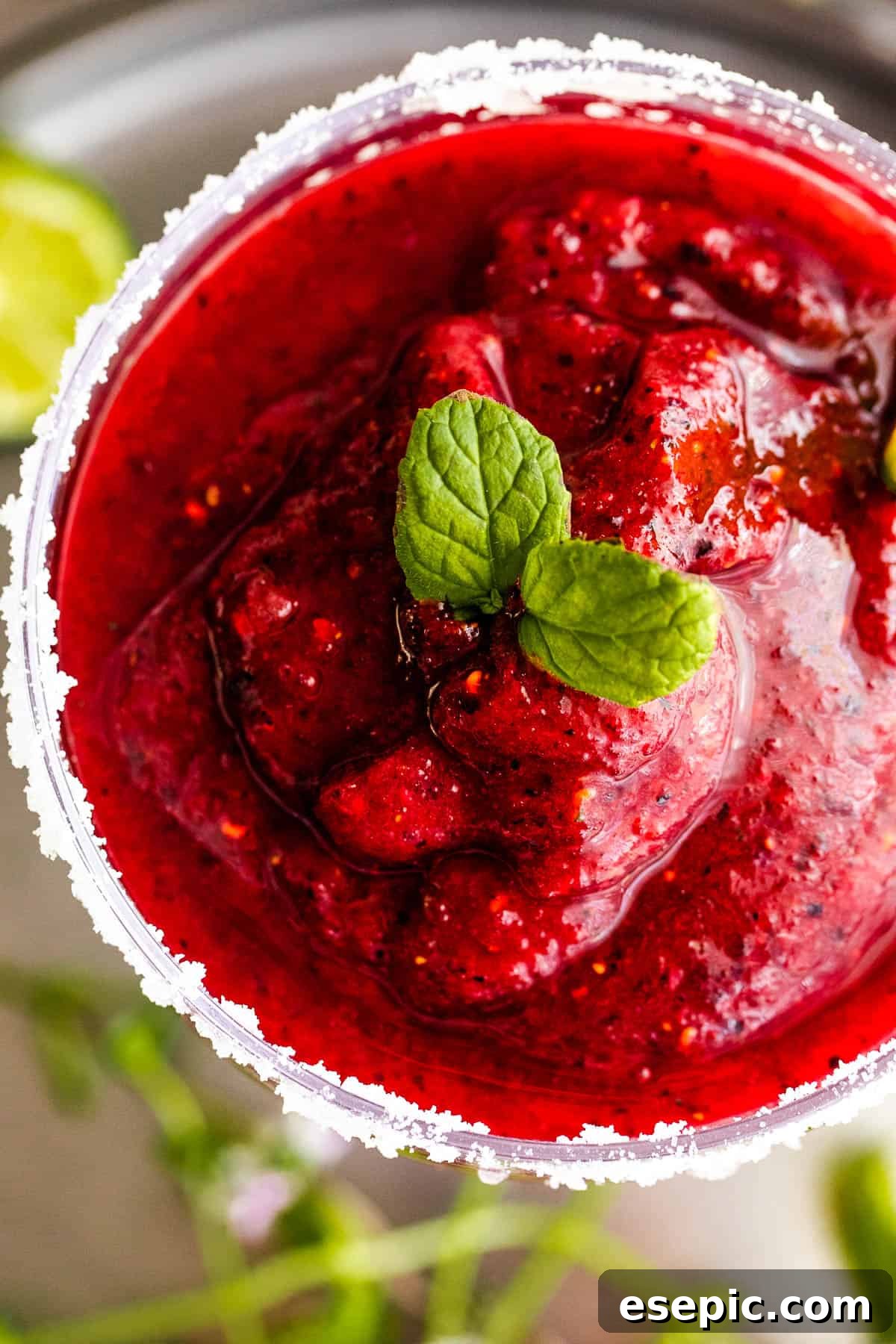 overhead close up shot of Frozen Berry Margarita served in a margarita glass and garnished with mint