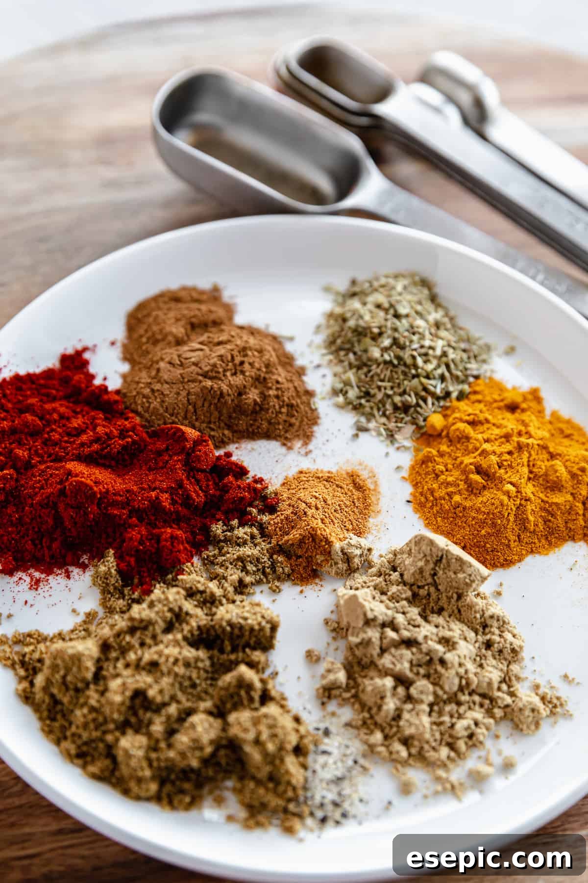 A Shallow Plate Containing Shawarma Spices Beside a Set of Metal Measuring Spoons