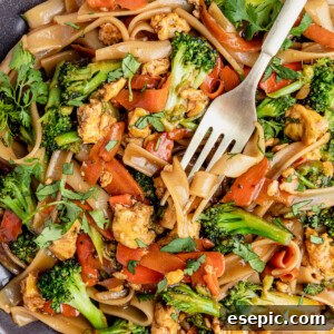 A Fork Digging Into a Big Plate of Pad See Ew