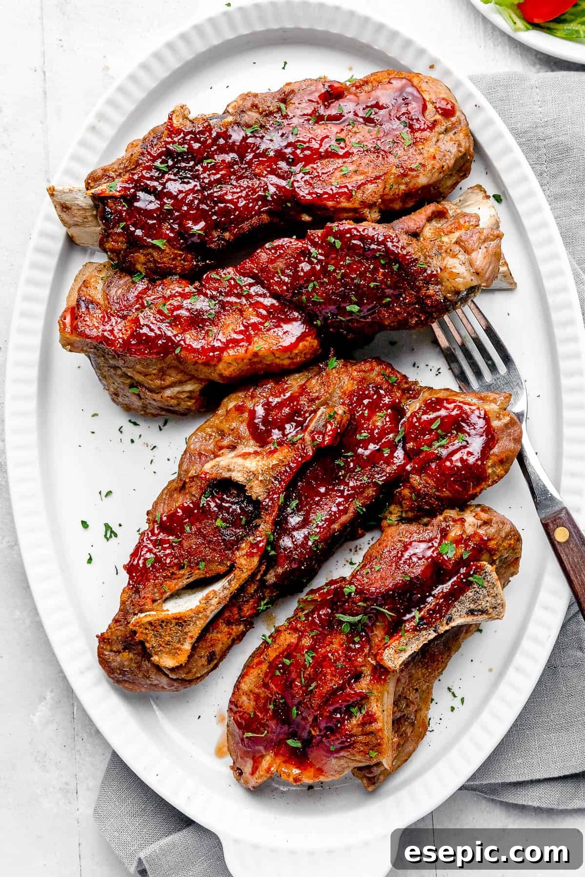 Four Instant Pot Ribs Garnished with Chopped Parsley on a White Plate