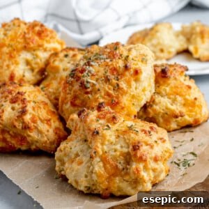 Six Air Fryer Biscuits on a Piece of Parchment Paper Over a Wooden Board