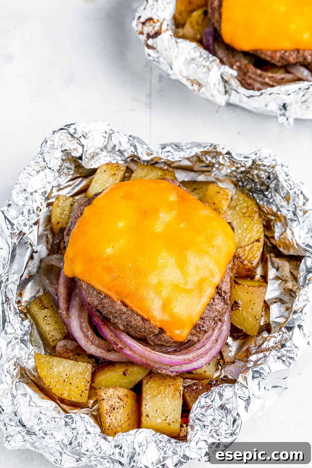 Cheeseburger Foil Dinner with Roasted Vegetables 5 Two cheeseburgers in foil with potatoes