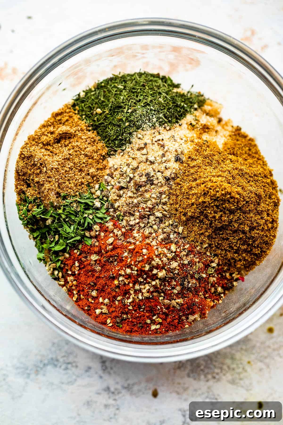 Freshly mixed seafood seasoning in a small bowl with spices around it