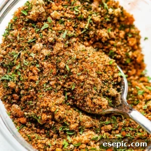 seafood seasoning blend in a small glass mixing bowl with a teaspoon inside