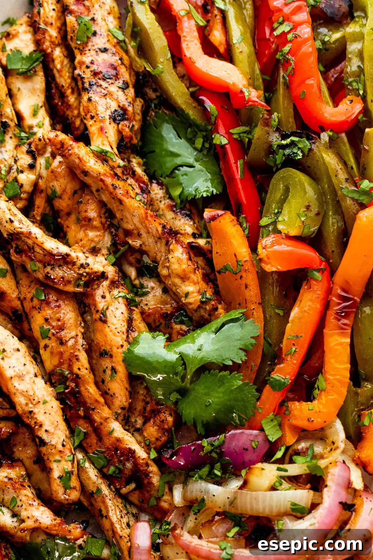 Easy grilled chicken fajitas featuring juicy chicken, onions, and peppers, served in warm tortillas with your favorite toppings. close up photo of grilled chicken and bell peppers for grilled chicken fajitas