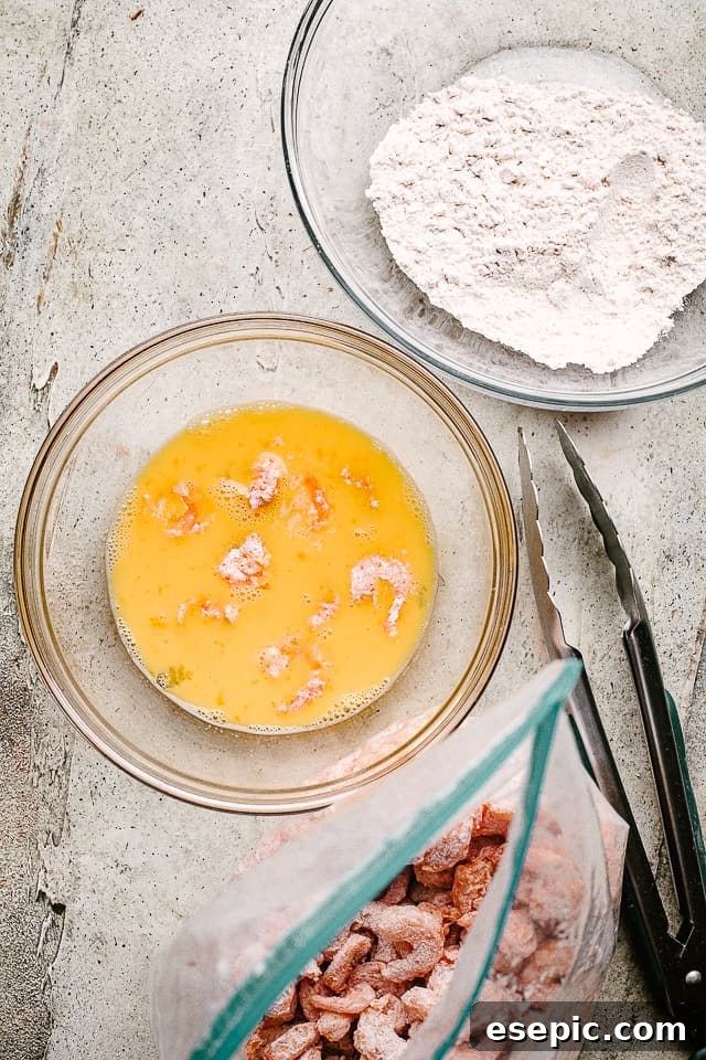 Achieve perfectly coated and crispy popcorn shrimp by setting up an efficient breading station. A three-bowl breading station setup for making popcorn shrimp, showing flour, egg wash, and seasoned flour mixtures.