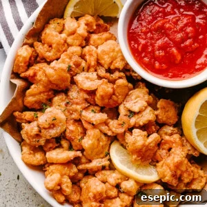Popcorn shrimp on a plate with lemon and dipping sauce