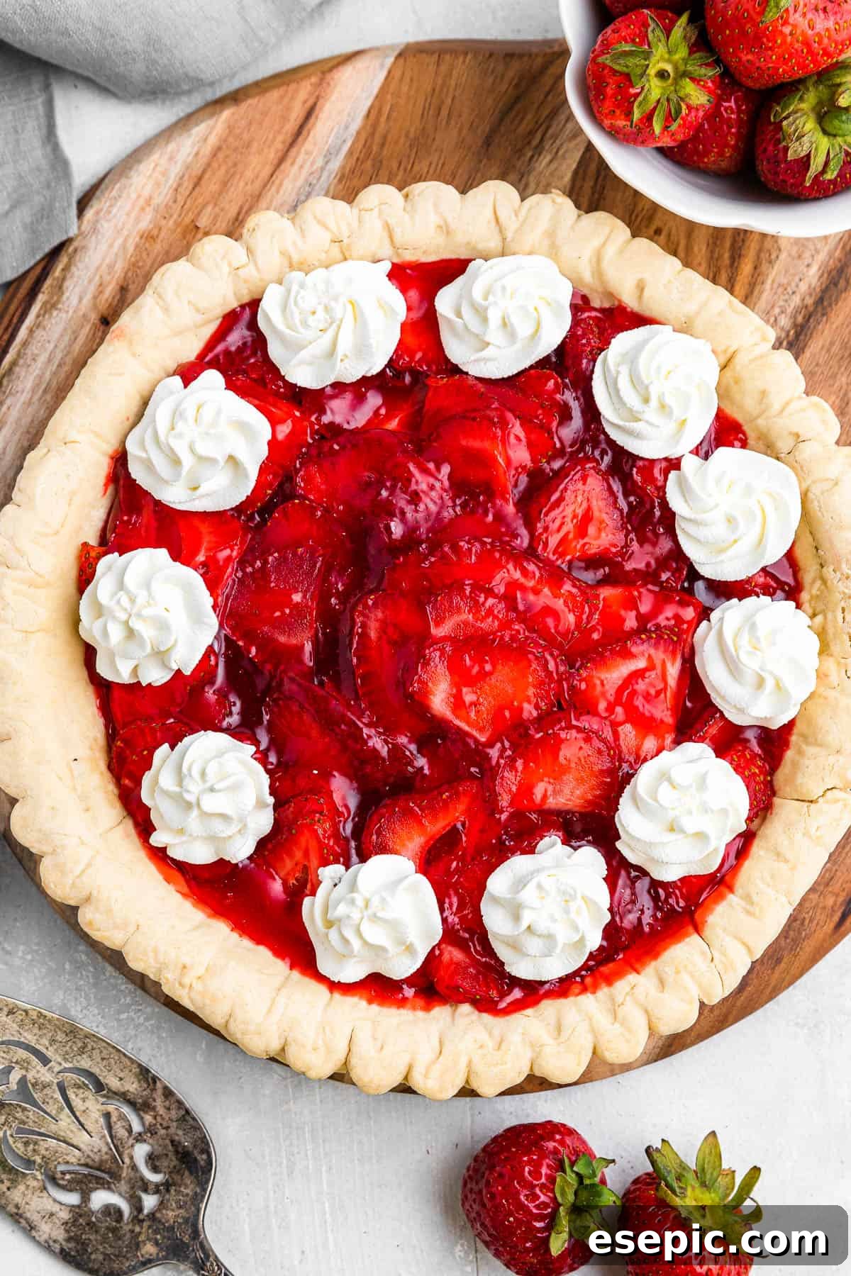 overhead shot of strawberry pie garnished with dollops of cream