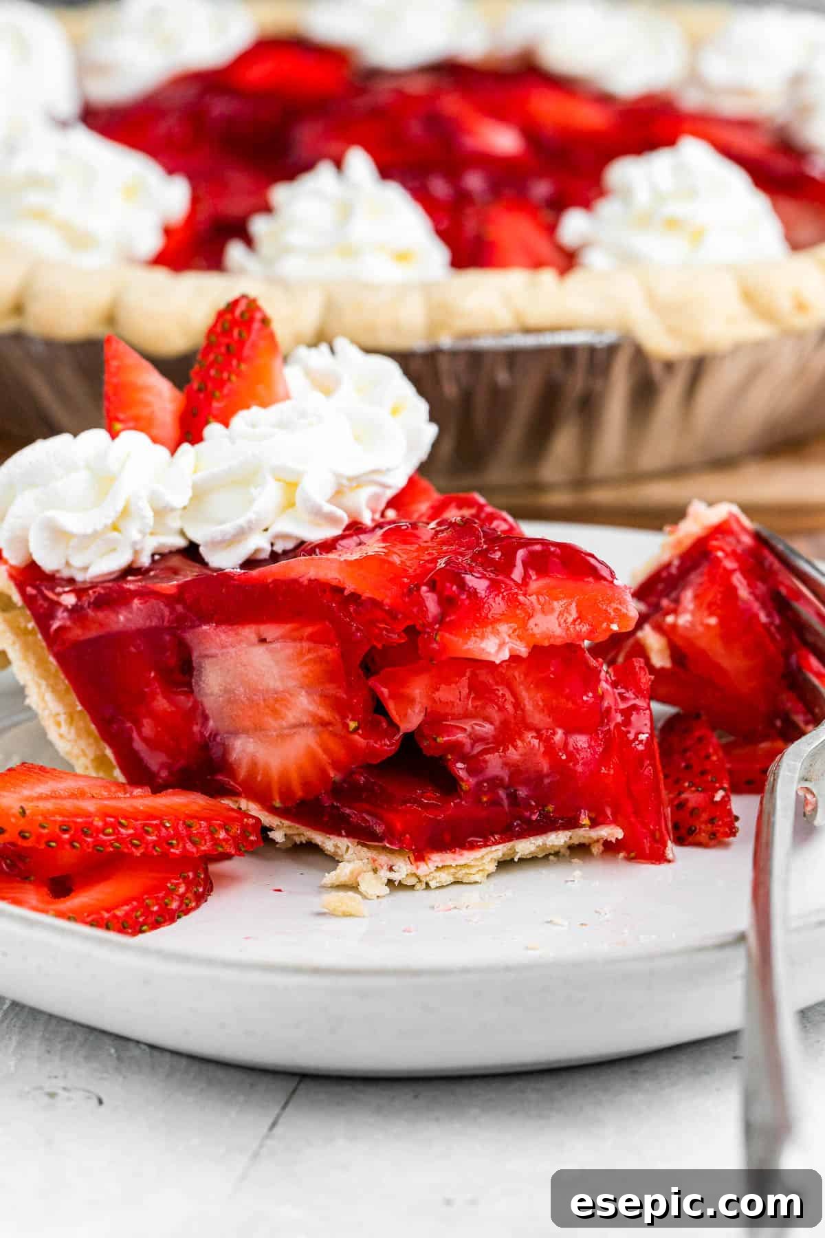 a slice of strawberry pie set on a plate with a fork