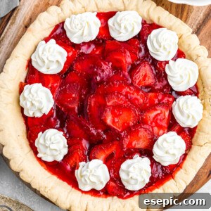 overhead shot of strawberry pie garnished with dollops of cream
