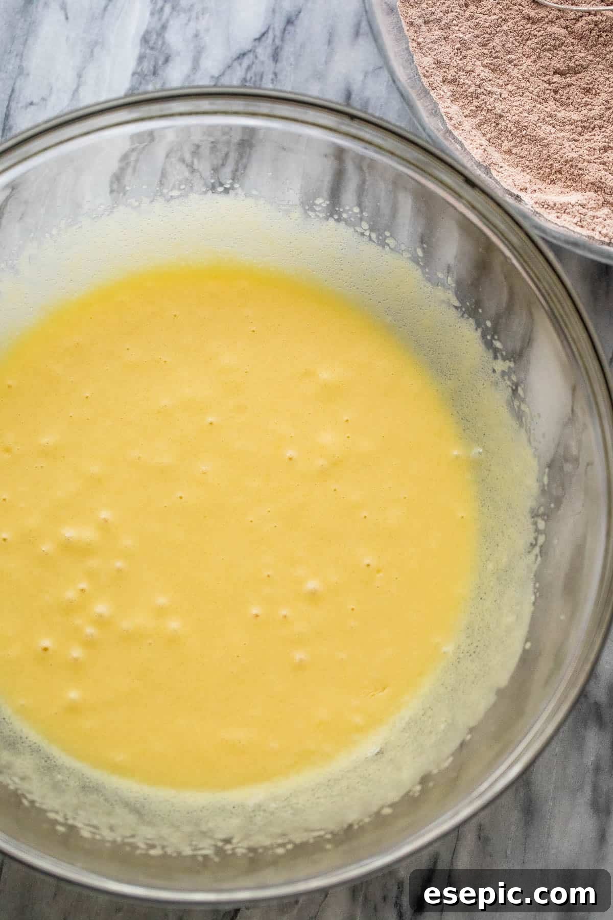 Mixing wet ingredients into dry ingredients for chocolate zucchini bread batter in a large bowl.