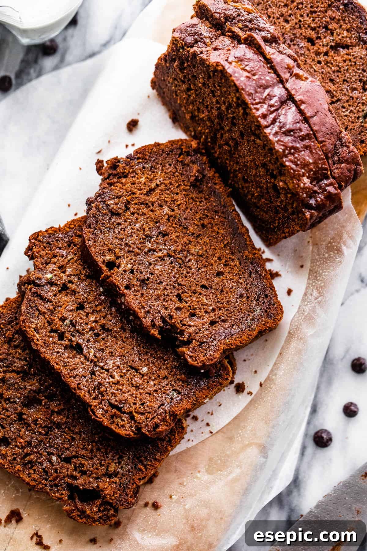 Overhead shot of freshly sliced chocolate zucchini bread on a cutting board, with a knife beside it.