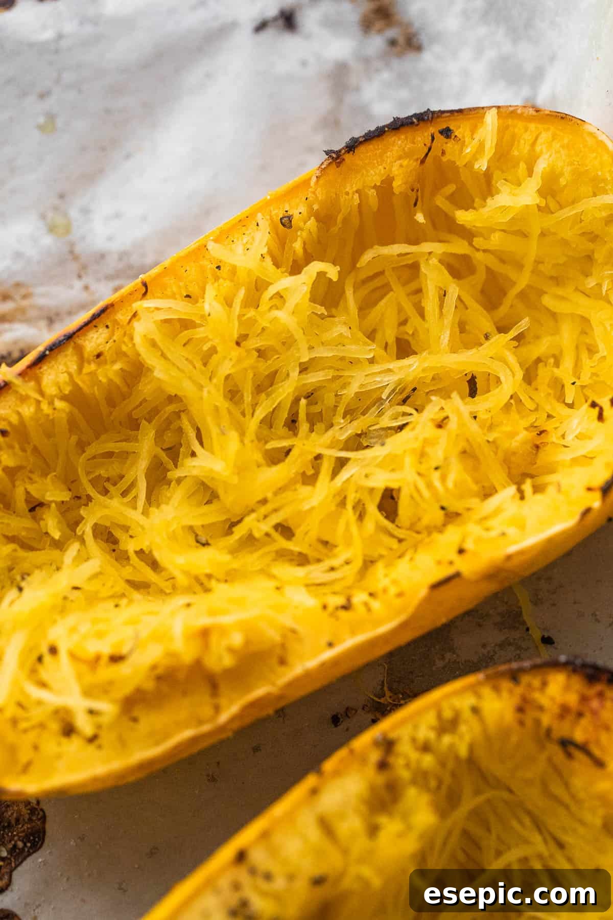 Spaghetti squash halves on a baking sheet, ready for the oven