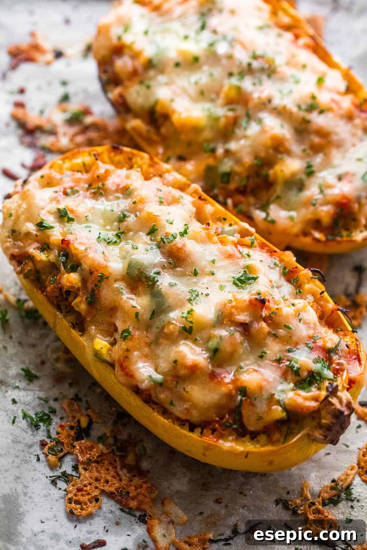 Two halves of spaghetti squash generously stuffed with cheesy chicken enchilada filling