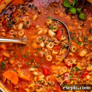 pasta fagioli soup in a white dutch oven with ladle inside the soup