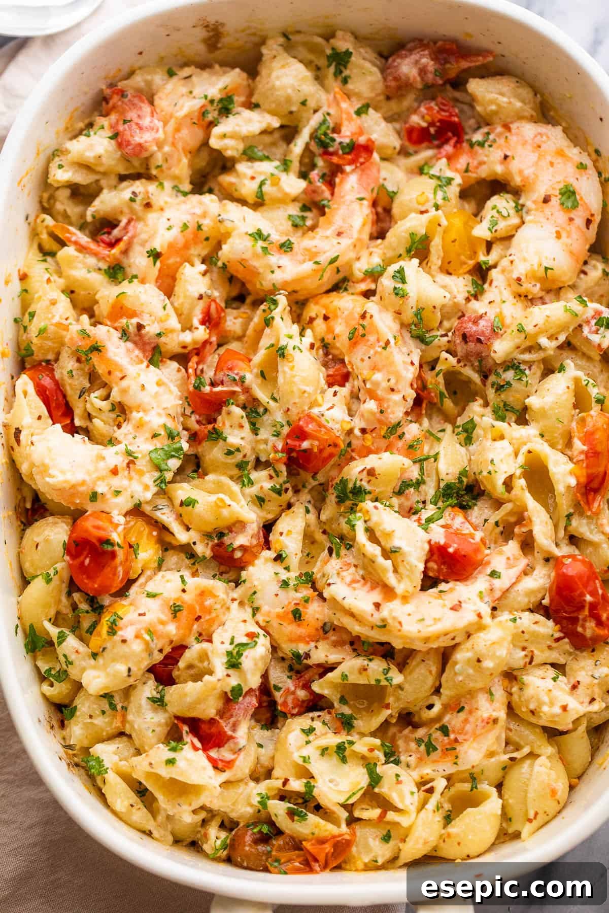Cream Cheese and Shrimp Pasta Bake 2 white baking dish with shrimp and pasta tossed with a cream cheese sauce and cherry tomatoes
