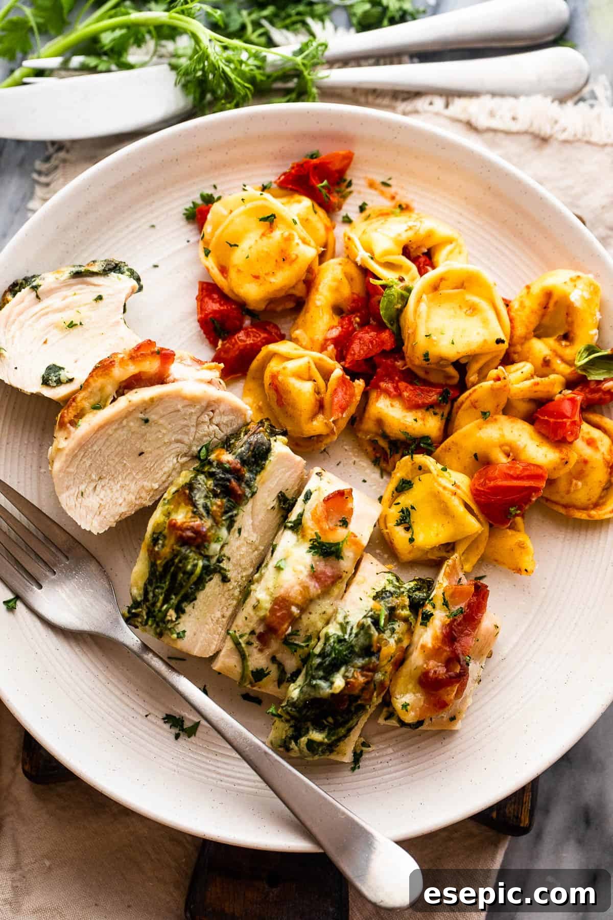 Creamy Spinach Bacon Stuffed Chicken 6 Sliced stuffed chicken breast served with tortellini pasta, highlighting the interior filling.