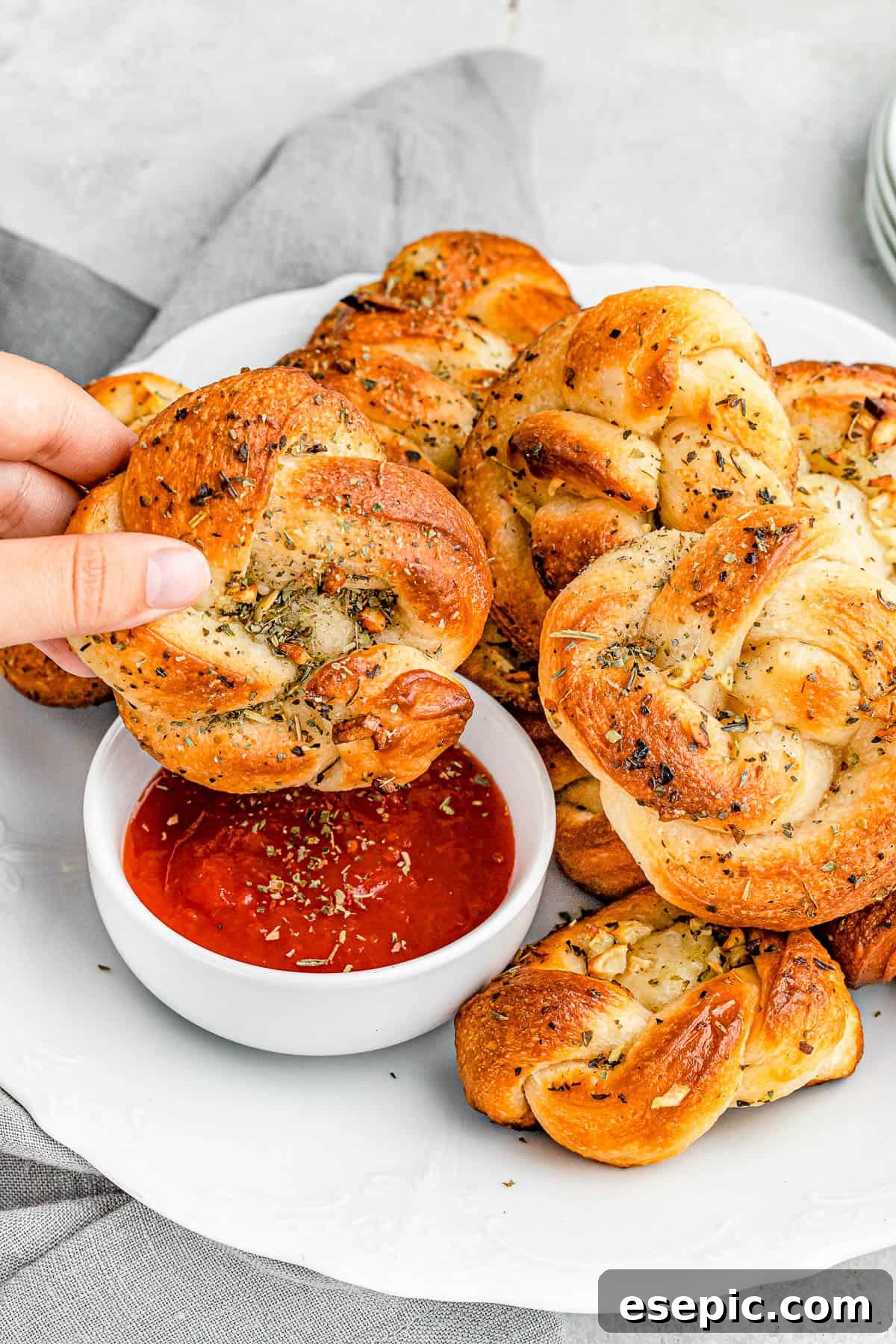 dipping garlic knots in marinara sauce.
