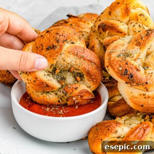 dipping garlic knots in marinara sauce.
