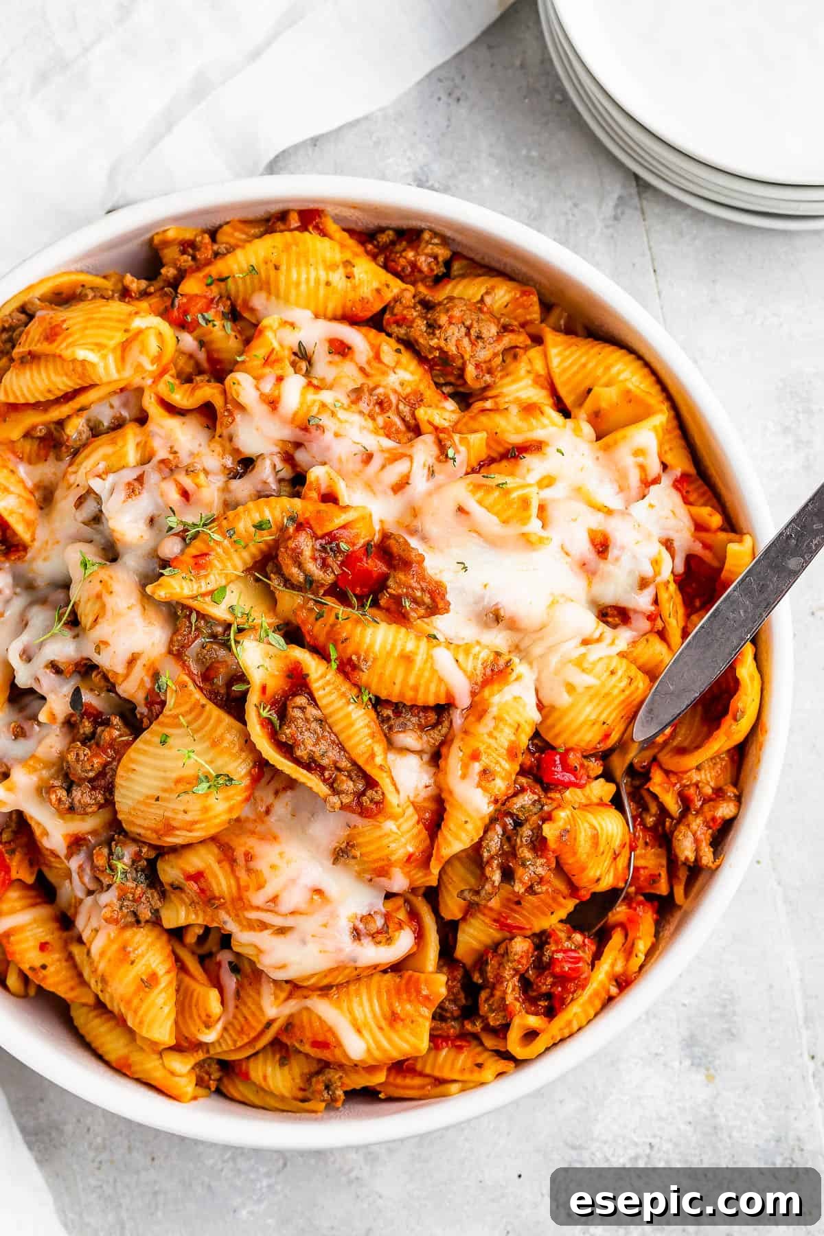 Instant Pot Hearty Beef and Shells 7 A serving dish filled with cooked pasta shells and ground beef in tomato sauce, topped with melted mozzarella.