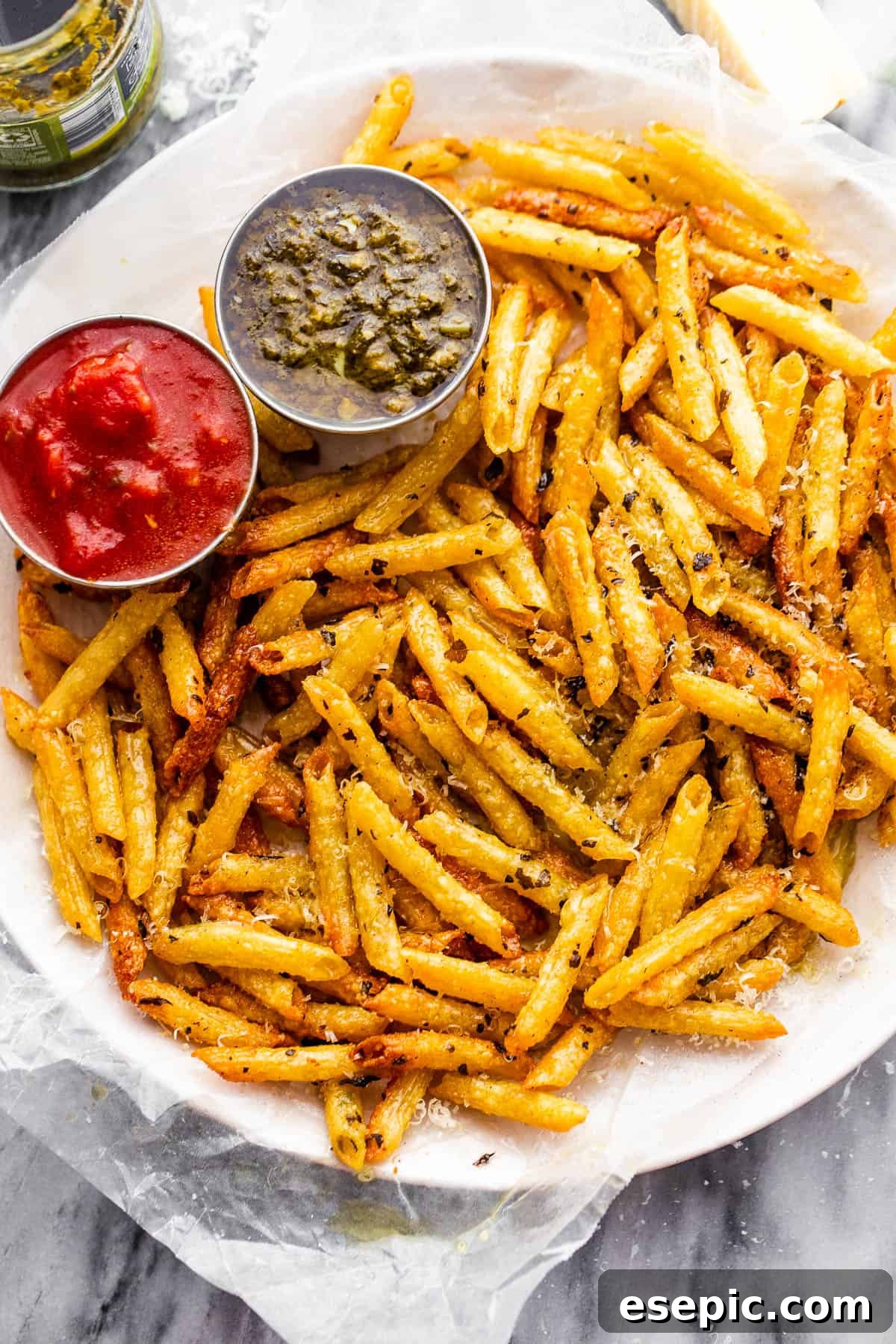 Crispy Pasta Chips Air Fry or Bake 3 A second close-up image of baked pasta chips served on a plate with dipping sauces, showcasing their golden crispness.