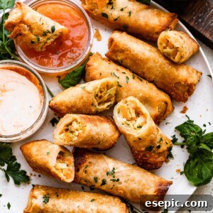A plate of spring rolls with dipping sauce.
