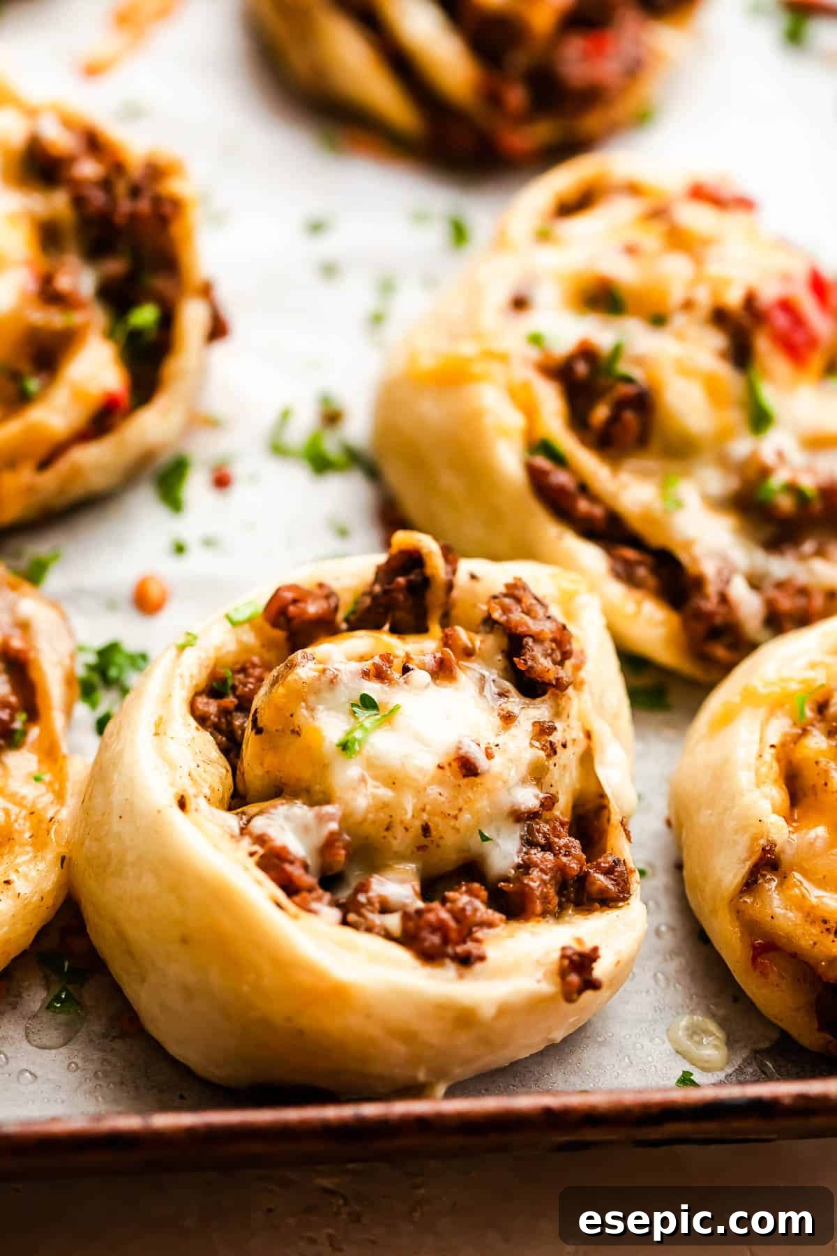 Cheesy Baked Taco Swirls 2 Cooked taco pinwheels on a baking sheet, golden brown and ready to serve.