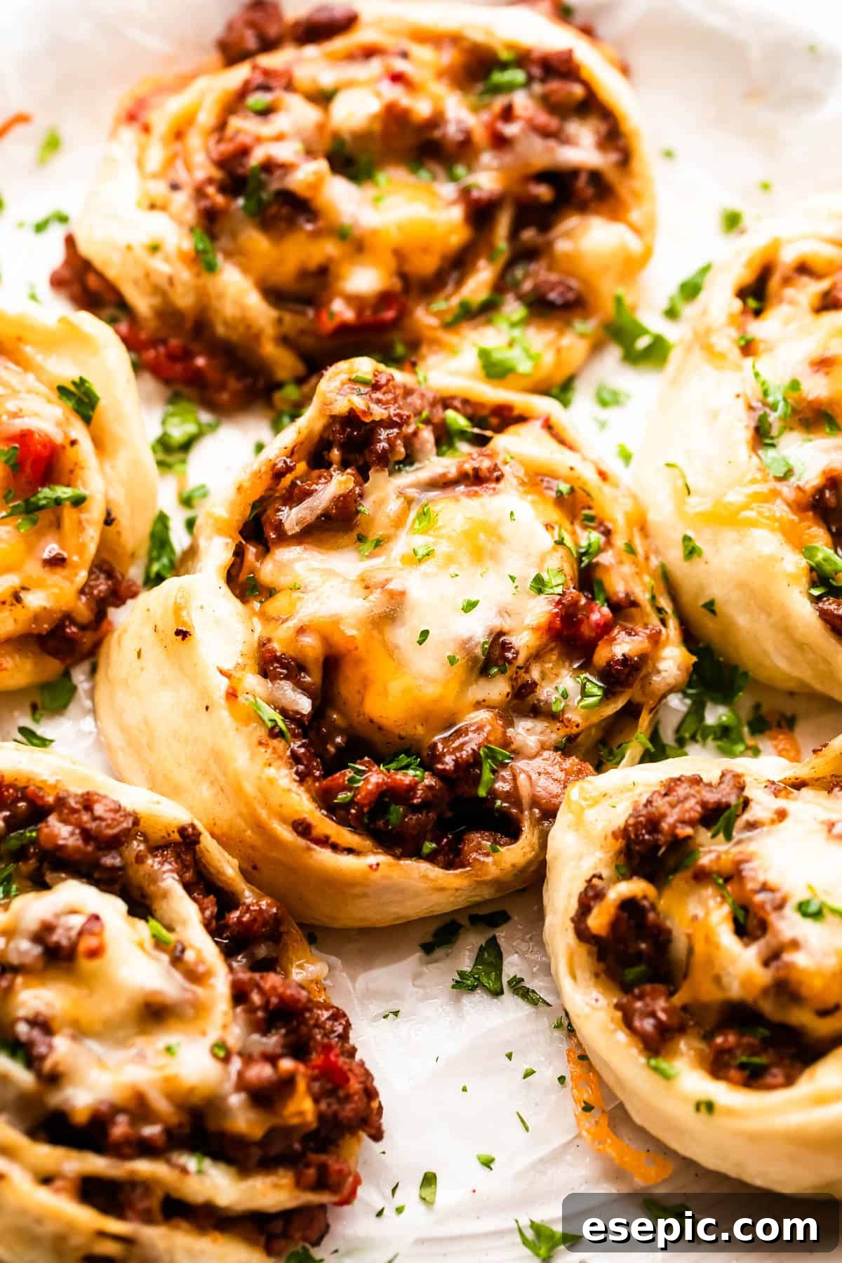 Cheesy Baked Taco Swirls 6 Perfectly cooked taco pinwheels served on a clean white background, garnished with fresh cilantro.