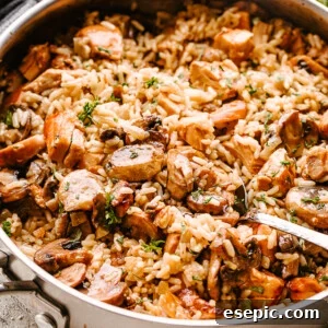 Chicken, mushrooms, and rice in a pan being stirred