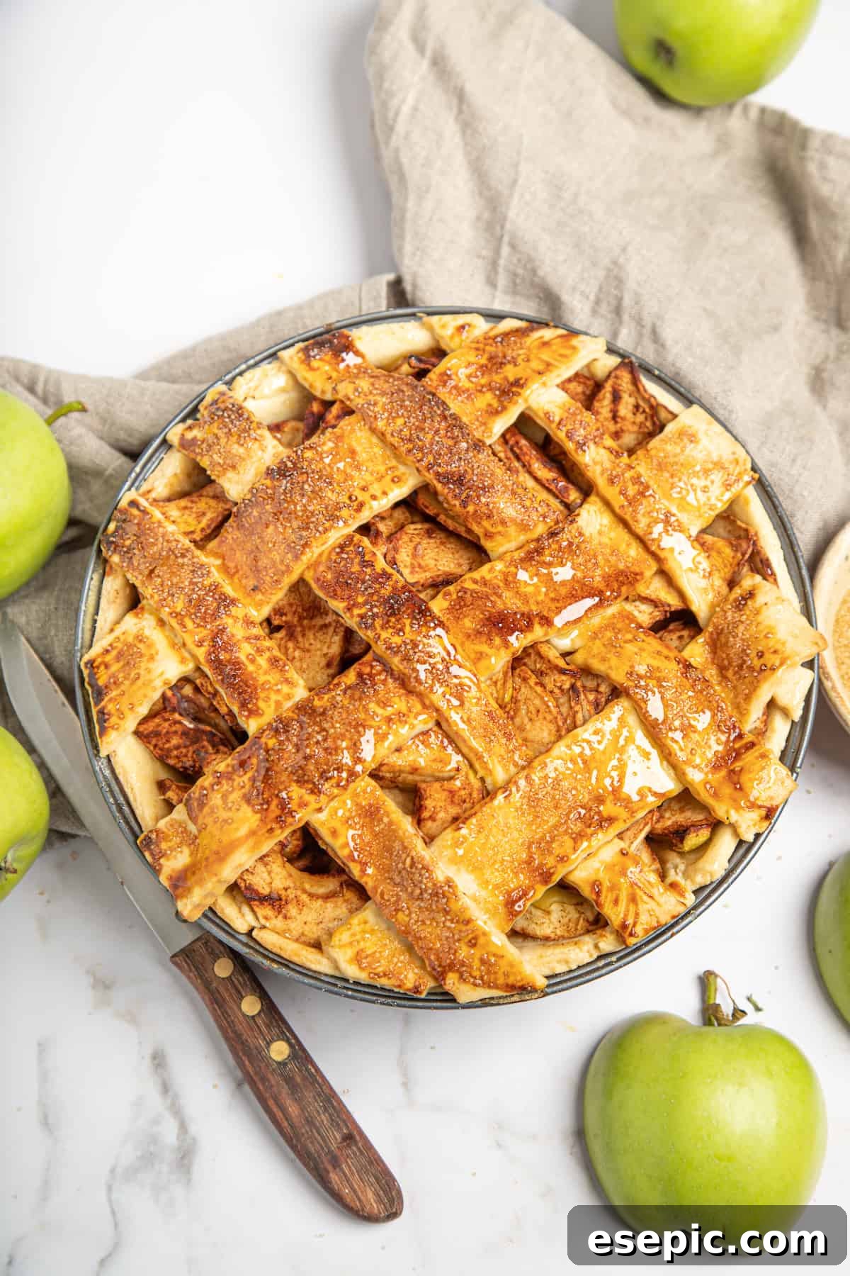 This classic yet easy and delicious Apple Pie recipe is made from scratch, with a buttery, flaky pie crust, fresh apple slices, pie spices, and brown sugar. A freshly baked homemade apple pie with a golden-brown lattice top, just out of the oven.