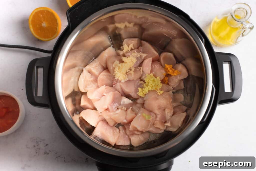 Effortless Instant Pot Orange Chicken 4 Cubed chicken in an Instant Pot.