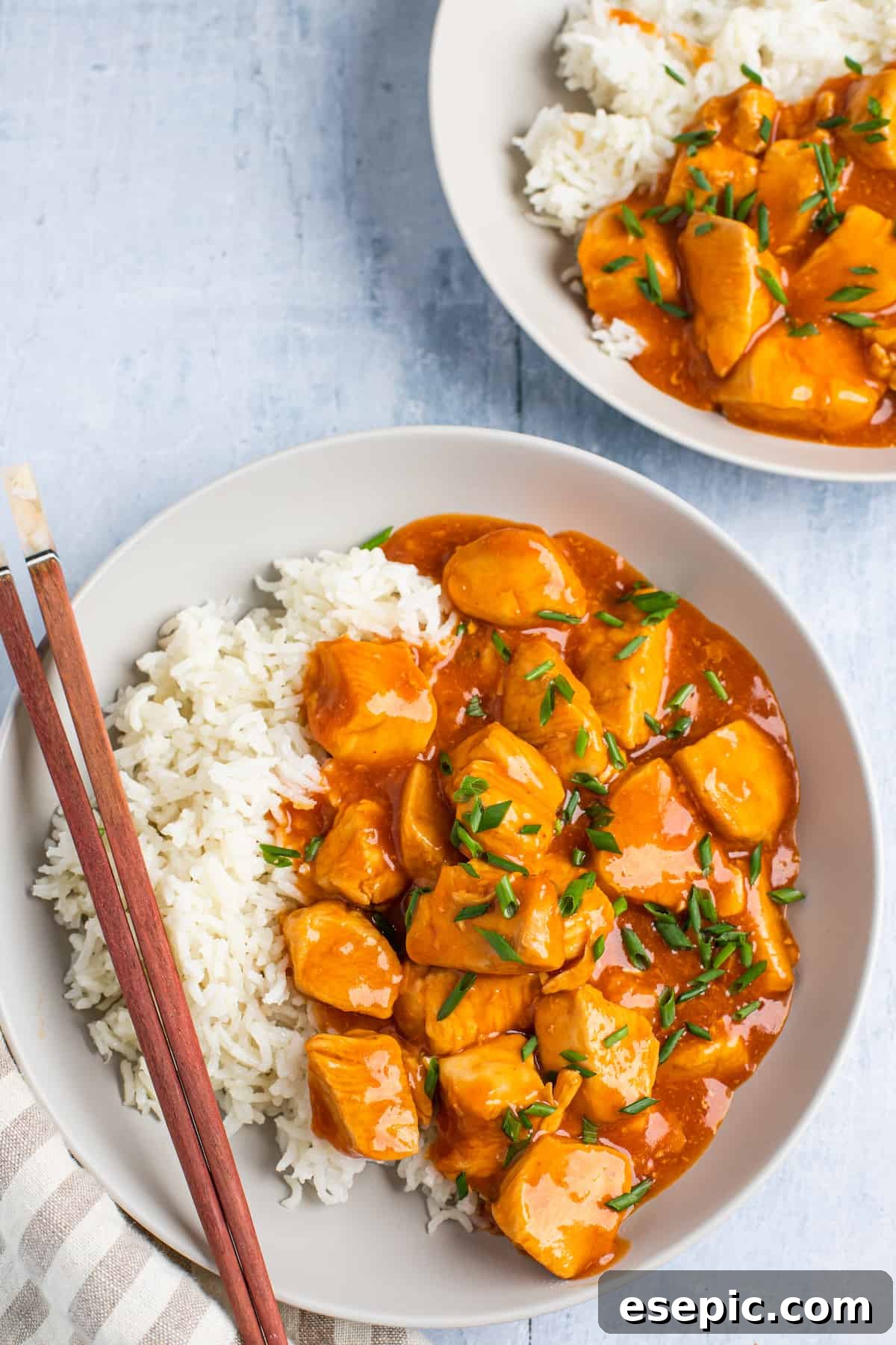 Effortless Instant Pot Orange Chicken 9 Two plates with servings of orange chicken and rice.