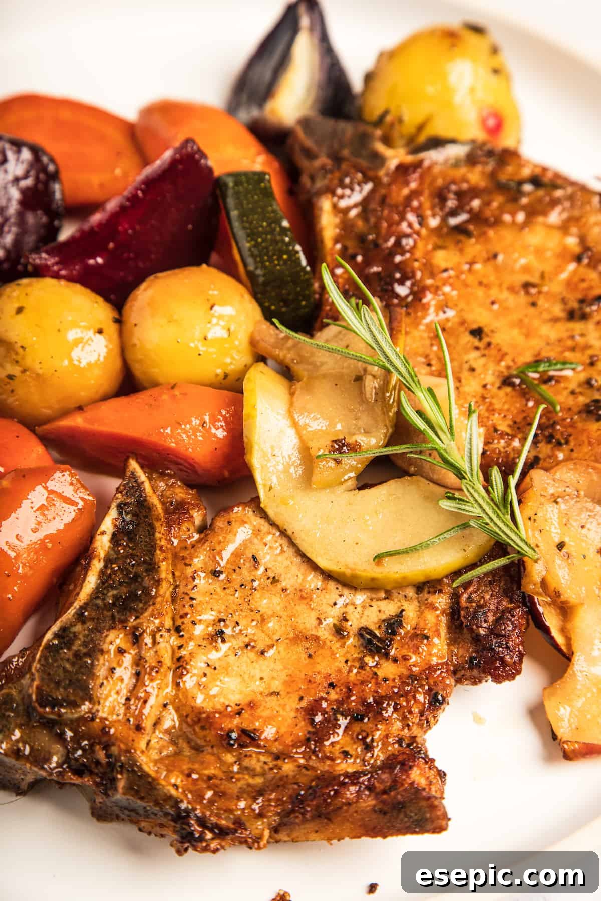 Roasted Pork Chops with Apples and Root Vegetables 7 A close-up shot of the beautifully cooked pork chops and mixed vegetables in the roasting pan, highlighting the golden-brown crust on the pork and the tender texture of the apples and veggies.