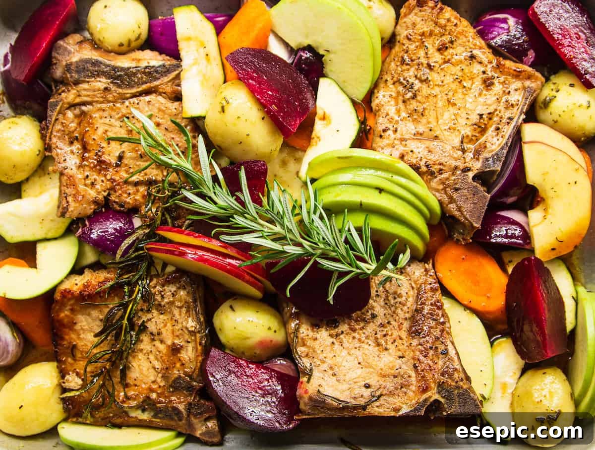 Roasted Pork Chops with Apples and Root Vegetables 8 A close-up overhead shot of the baking dish, featuring perfectly roasted pork chops, tender apples, and vibrant vegetables, all beautifully glazed with the reduced apple juice and rosemary sauce.