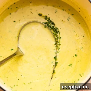 Simple Velvety Asparagus Soup 7 cream of asparagus soup in a pot with a ladle inside it.