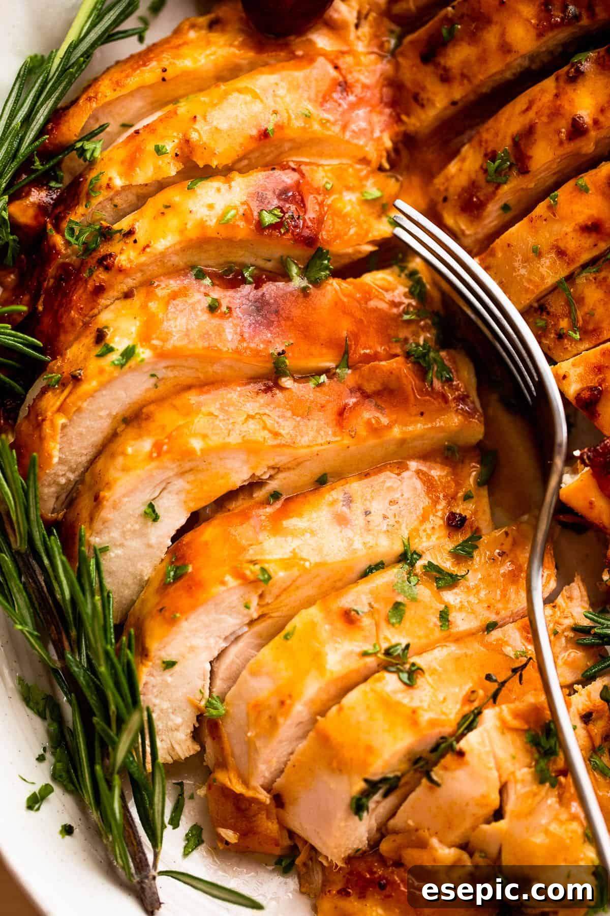 Roast a Perfect Turkey Breast Every Time 2 Sliced, perfectly cooked turkey breast glistening with juices, ready to be served, with a fork poised above a tender slice.