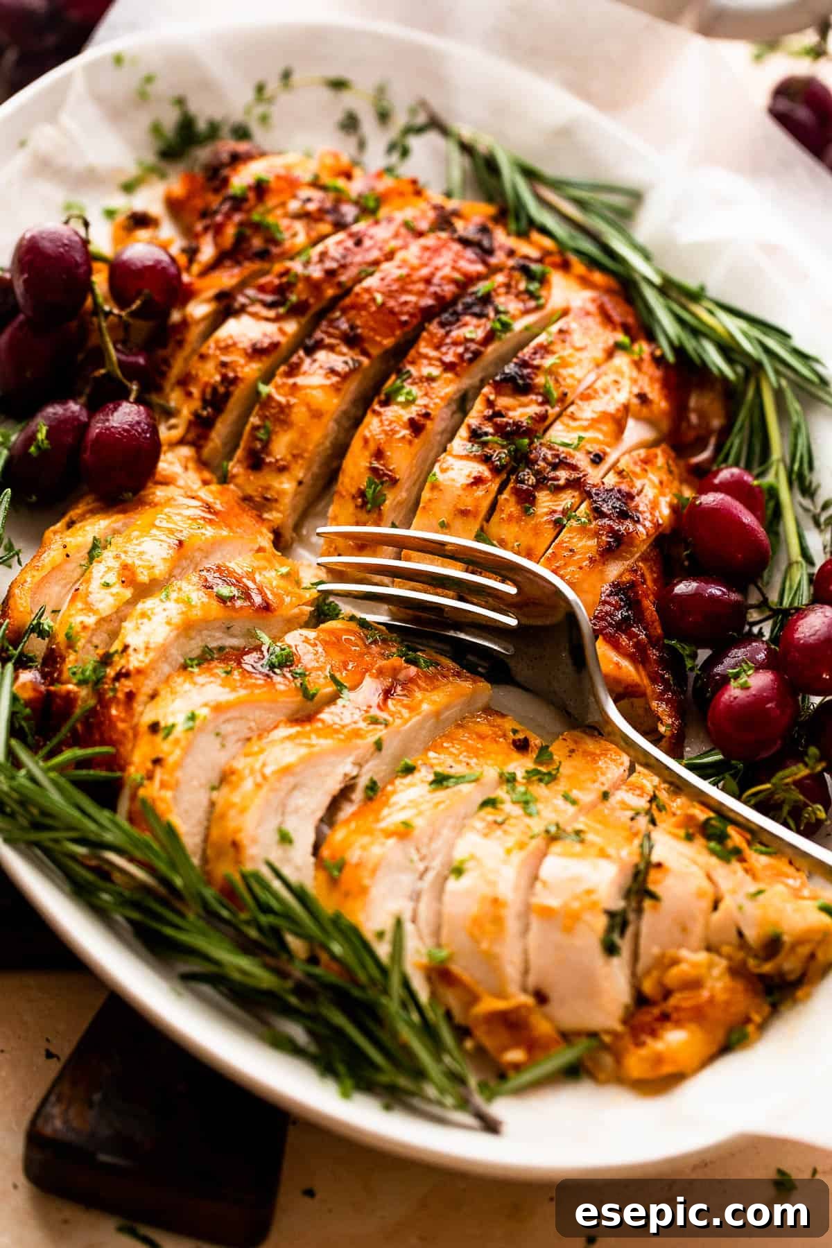 Secrets for a Succulent Roasted Turkey Breast 3 two turkey breasts sliced and arranged on a platter with rosemary and grape garnish