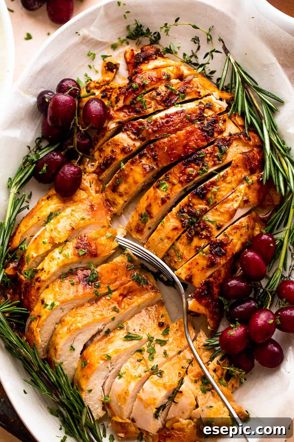 Secrets for a Succulent Roasted Turkey Breast 5 two turkey breasts sliced and arranged on a platter with rosemary and grape garnish