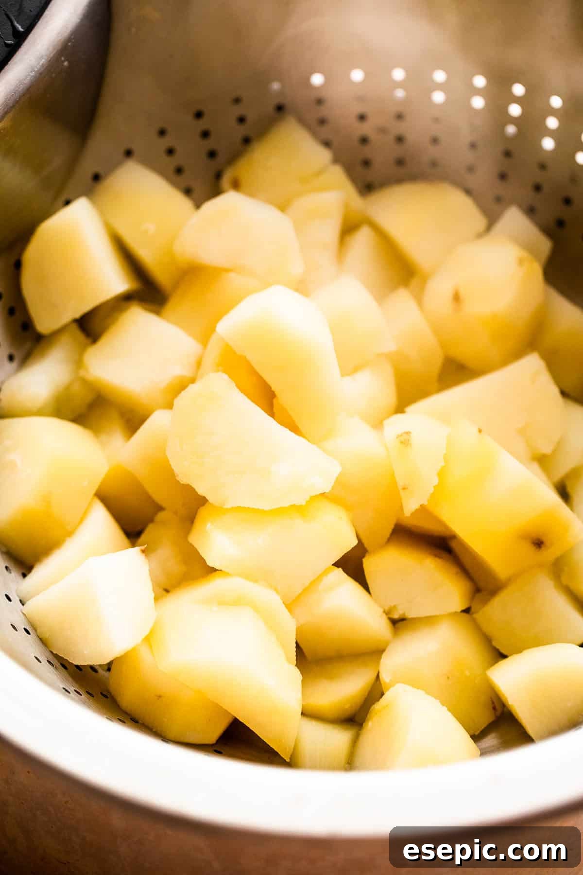 cooked diced potatoes in a collander