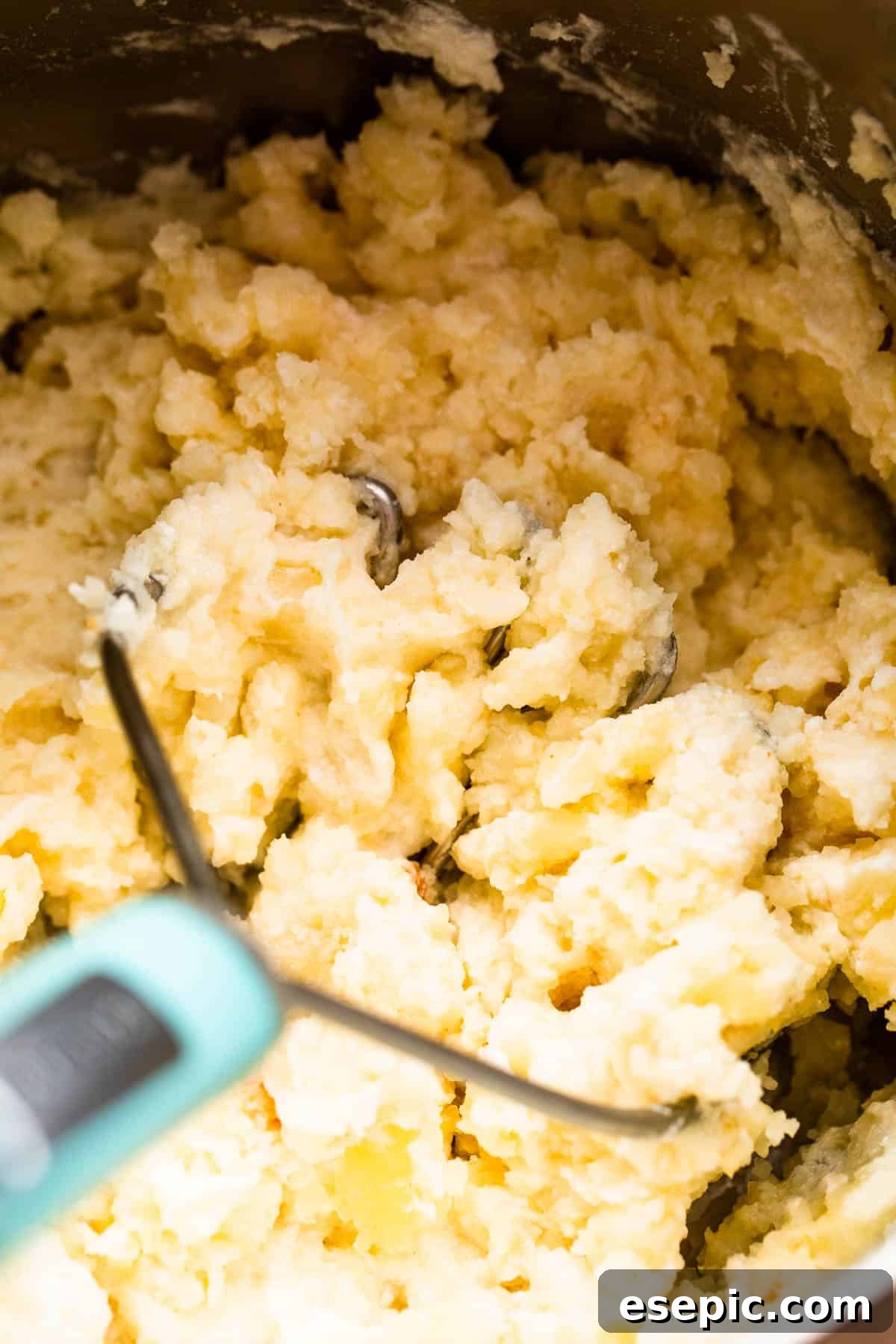mashing potatoes with a potato masher