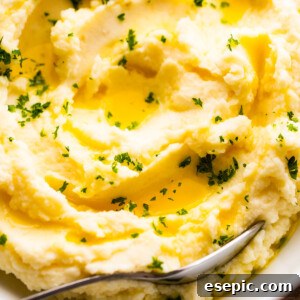 close up overhead shot of creamy mashed potatoes garnished with melted butter and parsley