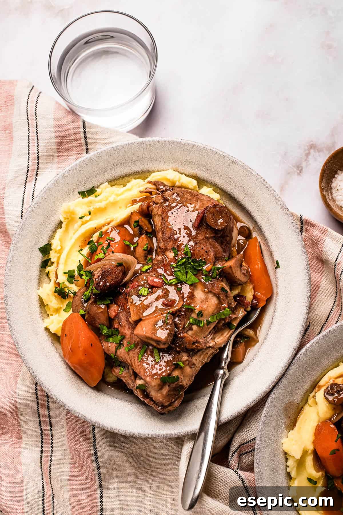 Quick and Classic Instant Pot Coq au Vin 10 A serving of coq au vin with mashed potatoes on a stoneware plate.