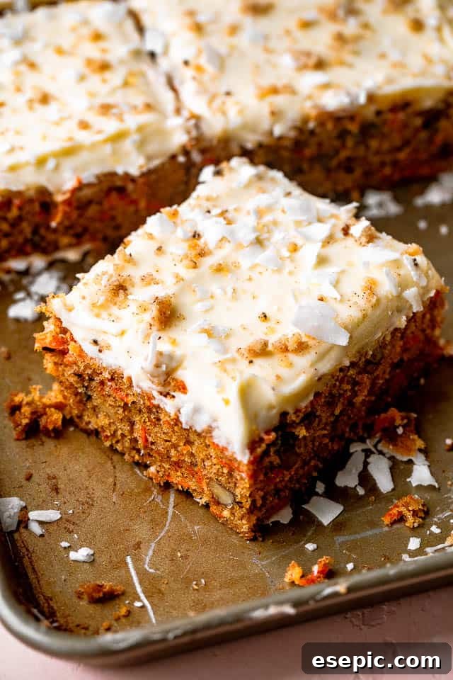 square slice of carrot cake with creamy white frosting and chopped walnuts